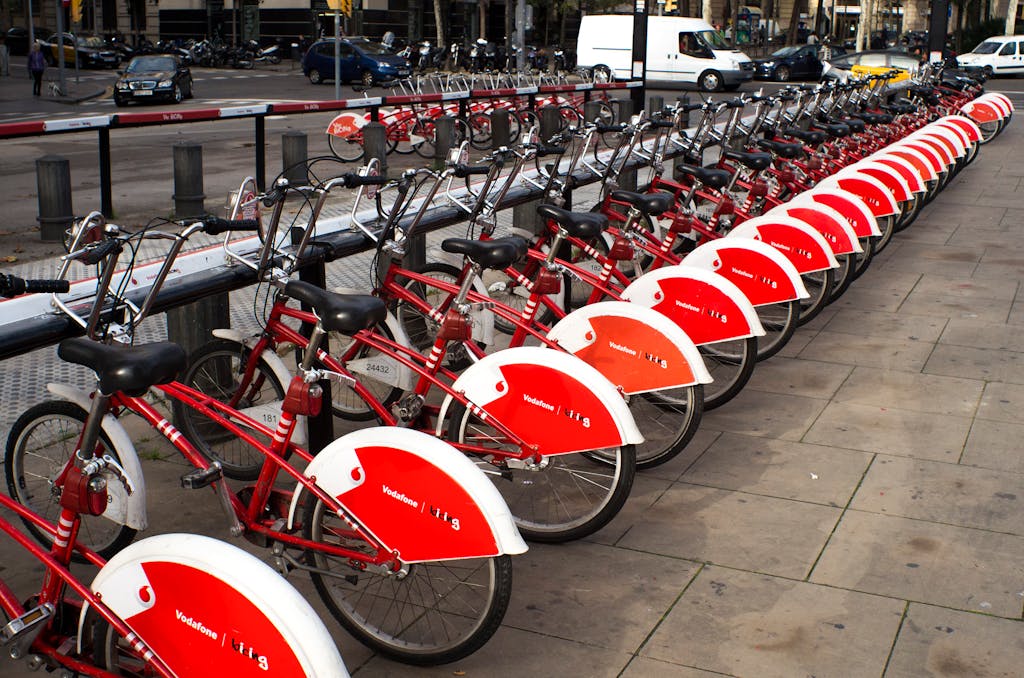 Guia para viajar a Barcelona. A long row of red rental bicycles parked in Barcelona city street.