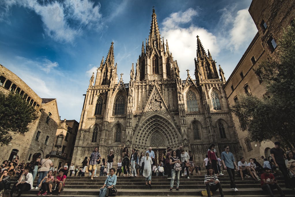 Guia para viajar por Barcelona, People gather at the impressive Gothic facade of Barcelona Cathedral in a bustling square.